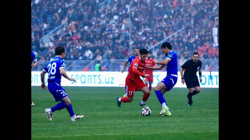 Cầu thủ của Andijan và Mash’al Muborak giao bóng trước sự áp đảo của đối thủ