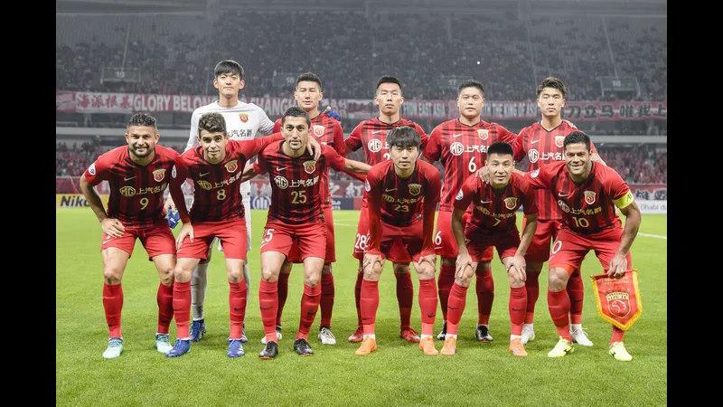 Hậu vệ Dalian Yingbo cản phá cú sút của tiền đạo Shanghai Port